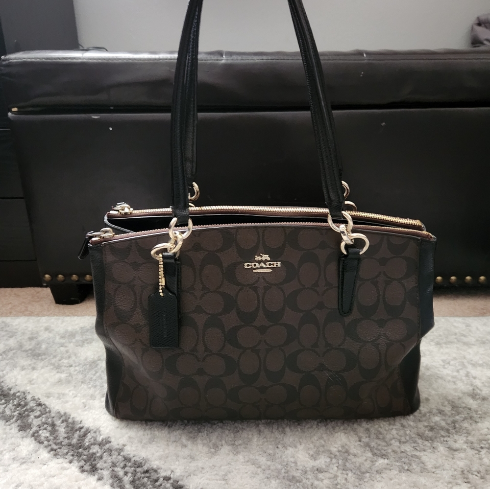 Large Brown Leather Signature Logo Coach Tote. It Has Gold Metal Accents.